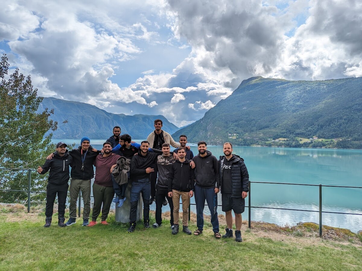 Group standing together at a panoramic viewpoint above turquoise fjord waters